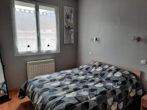 a bedroom with a bed and two windows at Aux bons thermes in Argelès-Gazost