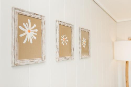 four pictures on a wall with white flowers at Sea View Snugs at Laggan in Gatehouse of Fleet