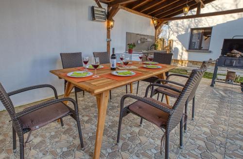 einen Holztisch mit Stühlen und Weingläsern darauf in der Unterkunft Guest House Stoyanovata Kashta - Стояновата къща in Elena