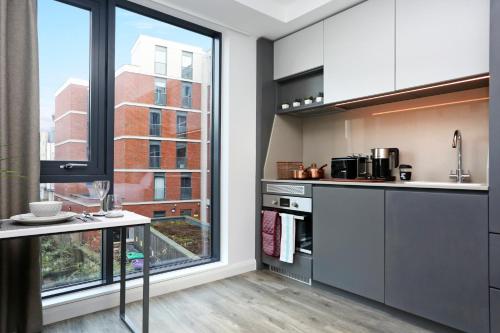 a kitchen with white cabinets and a large window at JOIVY at VITA Fountainbridge - Adults only - Breakfast buffet in Edinburgh