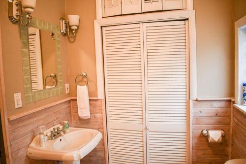 a bathroom with a sink and a toilet and a mirror at Brook Road Cabin in Goshen