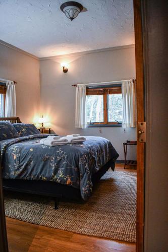 a bedroom with a bed with a blue comforter at Brook Road Cabin in Goshen