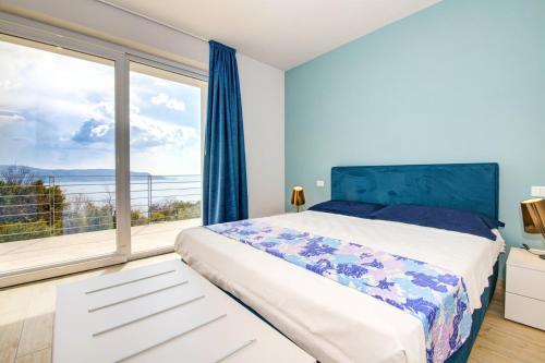 een slaapkamer met een bed en een groot raam bij Le Casette - Leccino in Toscolano Maderno