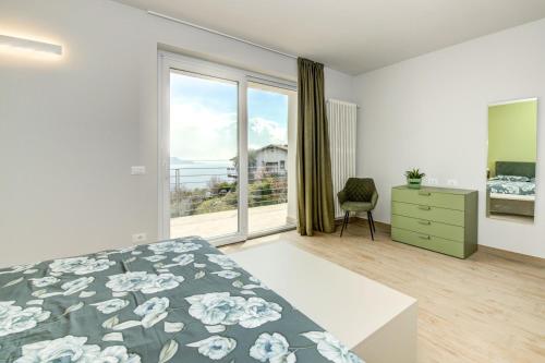 een slaapkamer met een bed en een groot raam bij Le Casette - Casaliva in Toscolano Maderno