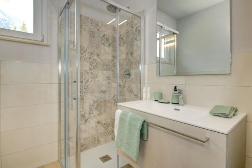 een badkamer met douche, wastafel en spiegel bij Le Casette - Casaliva in Toscolano Maderno