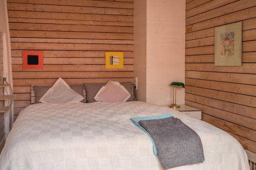 a bedroom with a bed with a wooden wall at Ferienwohnung Angelika in Konstanz