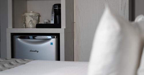 a small appliance in a shelf next to a bed at Hôtel Le Francis in New Richmond
