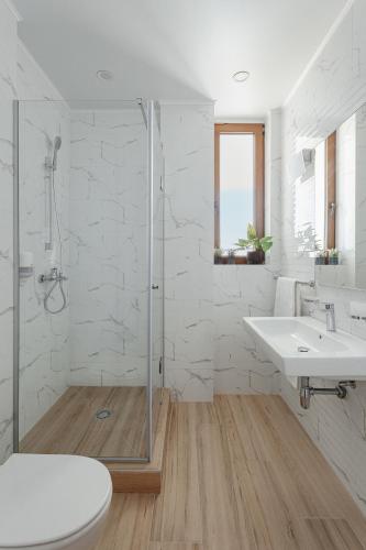 a white bathroom with a sink and a shower at Lucky Residence in Zatoka