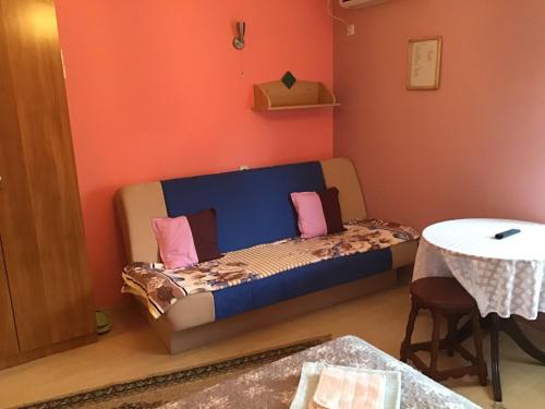 a bed in a room with a table and a table at Vila Verona Sobe in Palić
