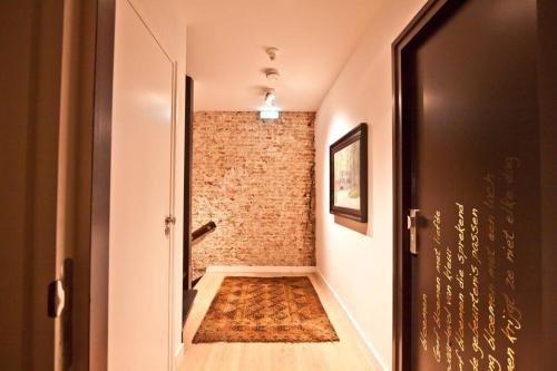 un couloir avec une porte et un mur en briques dans l'établissement Ginny's studio op de Grote Markt, à Breda
