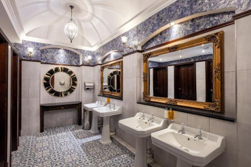 a bathroom with two sinks and two mirrors at The Newgrange Hotel in Navan