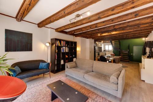 ein Wohnzimmer mit einem Sofa und einem Tisch in der Unterkunft Le Balcon du Château - Aprtement 75 square meter in the Annecy center in Annecy