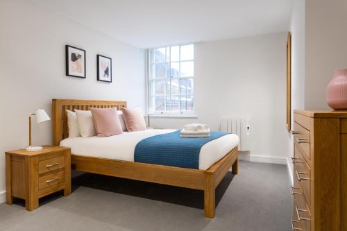 um quarto com uma cama e uma janela em Queens Park by Viridian Apartments em Londres