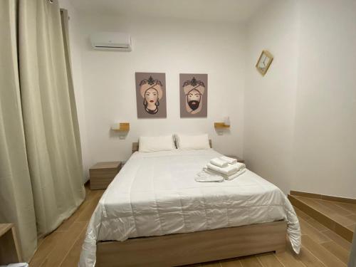 a bedroom with a bed with two pictures on the wall at La Casa Dei Mori in Melilli