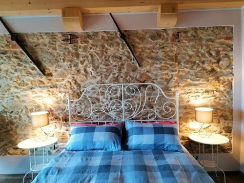 a bedroom with a bed with two lamps on tables at Le Moie in Borgiallo