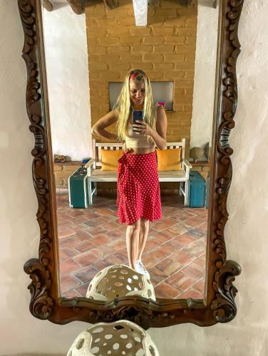 a woman taking a picture of herself in a mirror at Casona CHARA in Barichara
