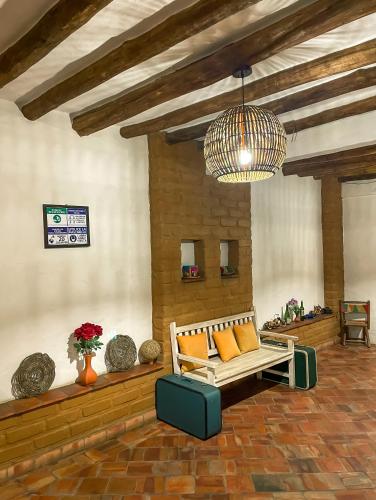 a living room with a bench and a chandelier at Casona CHARA in Barichara