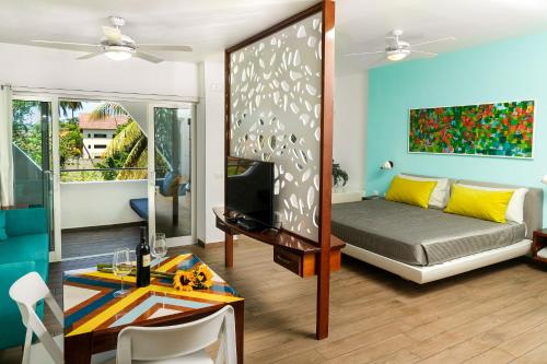 a living room with a bed and a tv at Puerto Plaza Las Terrenas in Las Terrenas