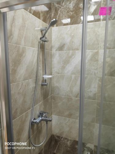 a shower with a glass door in a bathroom at Guest house boulevard 1 in Sumqayıt