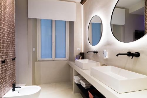 La salle de bains est pourvue de 2 lavabos et d'un miroir. dans l'établissement MADA Charm Apartments Piazza, à Vernazza