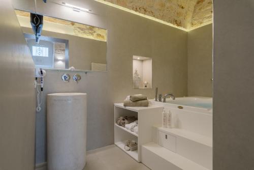 y baño con ducha, bañera y lavamanos. en Pregiata Suite 25, en Ostuni