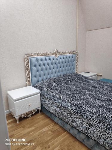 a bedroom with a blue bed and a white dresser at Guest house boulevard 1 in Sumqayıt