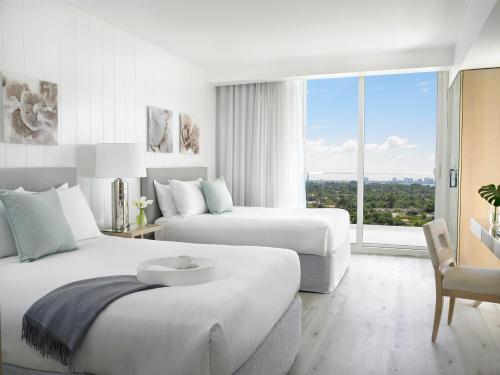 a hotel room with two beds and a large window at Grand Beach Hotel Surfside in Miami Beach