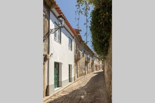 an alley in an old town with white buildings at Pilgrim suite in Vila do Conde