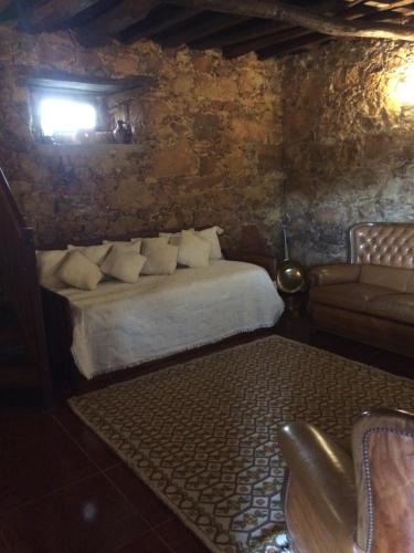 a bedroom with a bed and a couch in a room at Pátio das Mós in Vila Nova de Poiares