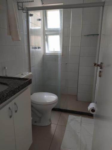 a white bathroom with a toilet and a shower at Hotel Porto Segur0 in Recife