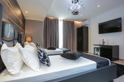 a large bedroom with two beds and a television at J'Me Boutique Hotel - Adults only in St Julian's