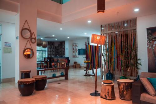 a living room with a couch and a table andools at Hotel Unión Plaza in Montería