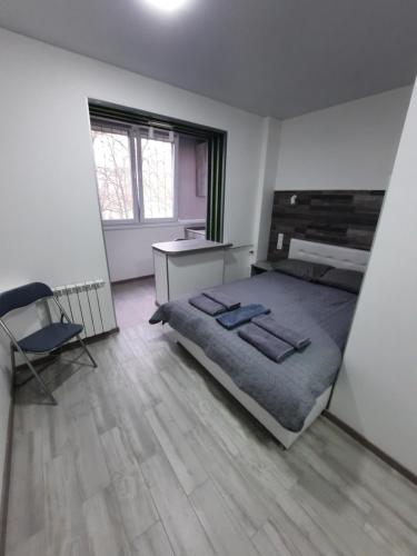 a bedroom with a bed and a desk and a chair at Посуточно мини-студия метро Минская Киев in Kyiv