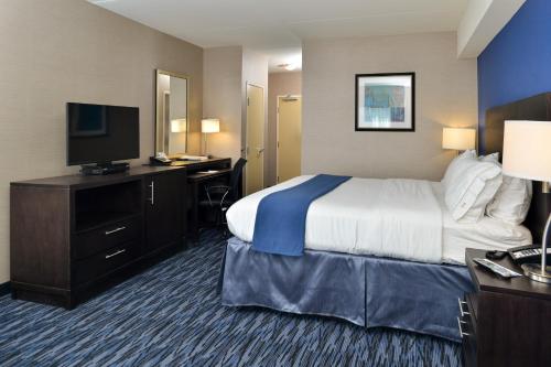 a hotel room with a bed and a flat screen tv at Holiday Inn Express & Suites Peekskill-Lower Hudson Valley, an IHG Hotel in Peekskill