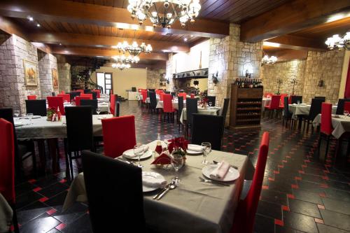 a dining room with tables and chairs and red chairs at Te'Dreri - Llogora Tourist Village in Dhërmi