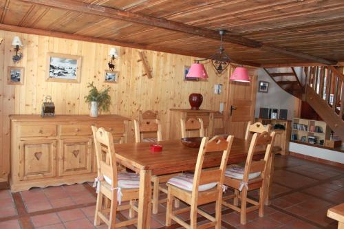 a dining room with a wooden table and chairs at Chalet Suisse Authentique in La Comballaz