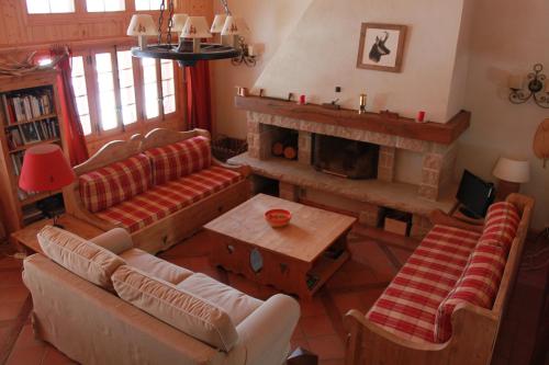 a living room with couches and a fireplace at Chalet Suisse Authentique in La Comballaz