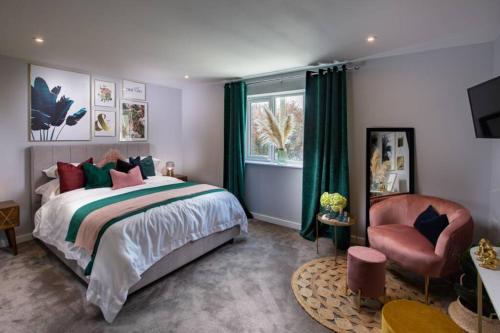 a bedroom with a bed and a chair and a window at Roseland Apartment 1 in Arundel