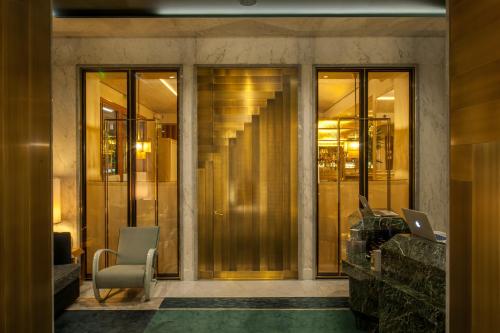 a lobby with glass doors and a laptop on a desk at Nolinski Paris - Evok Collection in Paris