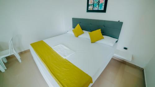 a bedroom with a bed with yellow pillows at Green Coveñas by Bernalo Hotels in Coveñas