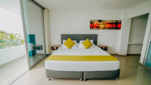 a bedroom with a large bed with yellow pillows at Green Coveñas by Bernalo Hotels in Coveñas
