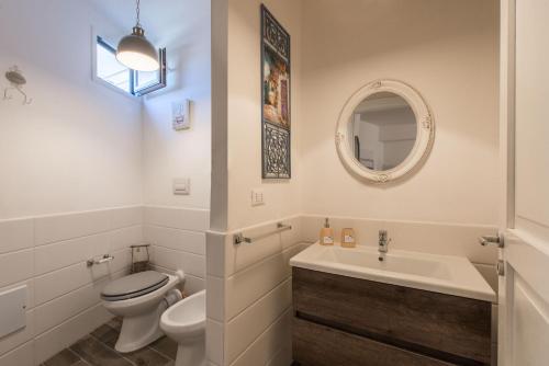 a white bathroom with a toilet and a sink at Villa Cinzia-150 mt from the beach in Mondello