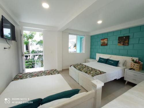 een slaapkamer met 2 bedden en een televisie. bij Hotel Boutique los Remansos in Palmira