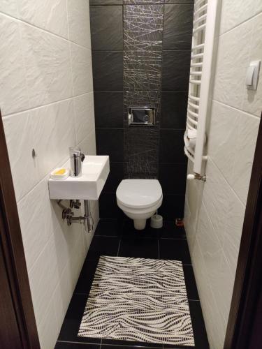 a bathroom with a white toilet and a sink at Center Rooms in Jarosław