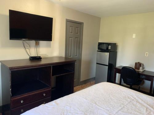 a hotel room with a bed and a desk with a television at Stadium View Inn in Hamburg
