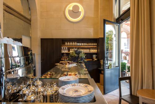 a restaurant with a counter with plates and dishes at Cour des Vosges - Evok Collection in Paris