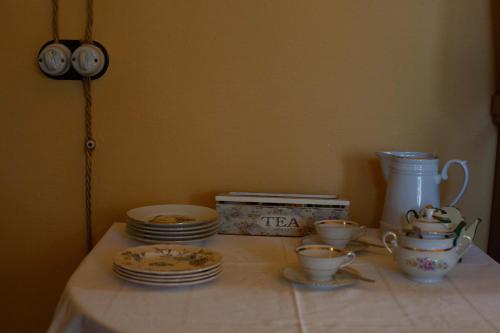 a table with plates and cups and a clock at B&B La Baita in Aritzo