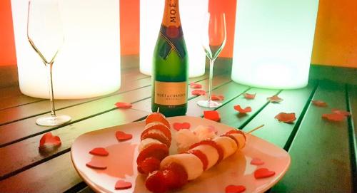 a plate with two hot dogs and a bottle of wine at Hotel Spa Galatea in Burela de Cabo