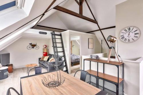 une chambre avec une table, des chaises et une horloge dans l'établissement LE VINTAGE 50 m de la plage en baie de Somme, à Cayeux-sur-Mer