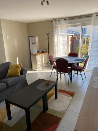 un salon avec un canapé et une table dans l'établissement Au Rythme des Vagues, à Saint-Aubin-sur-Mer